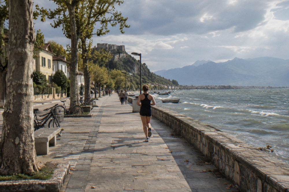 A lowland city of broad pedestrian boulevards lined with low painted houses, bicycles and plane trees with distant jagged mountains